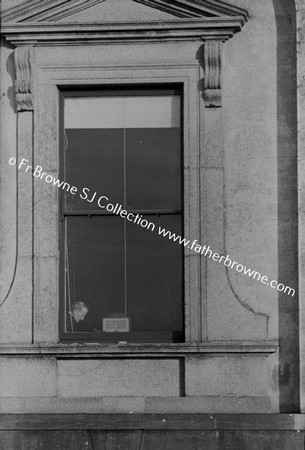 FR S BARTHLEY READING AT WINDOW OF LIBRARY